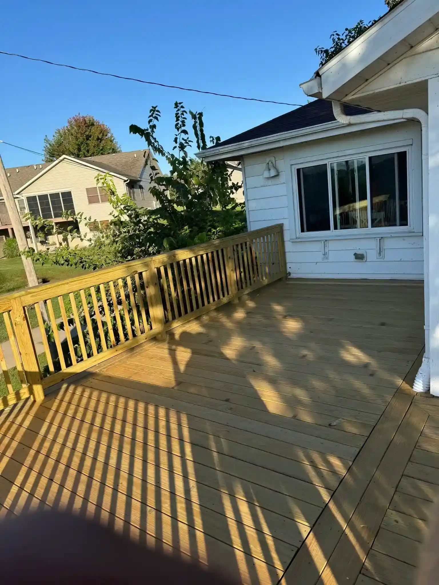 sunlit wood deck along a home in Davenport, Iowa