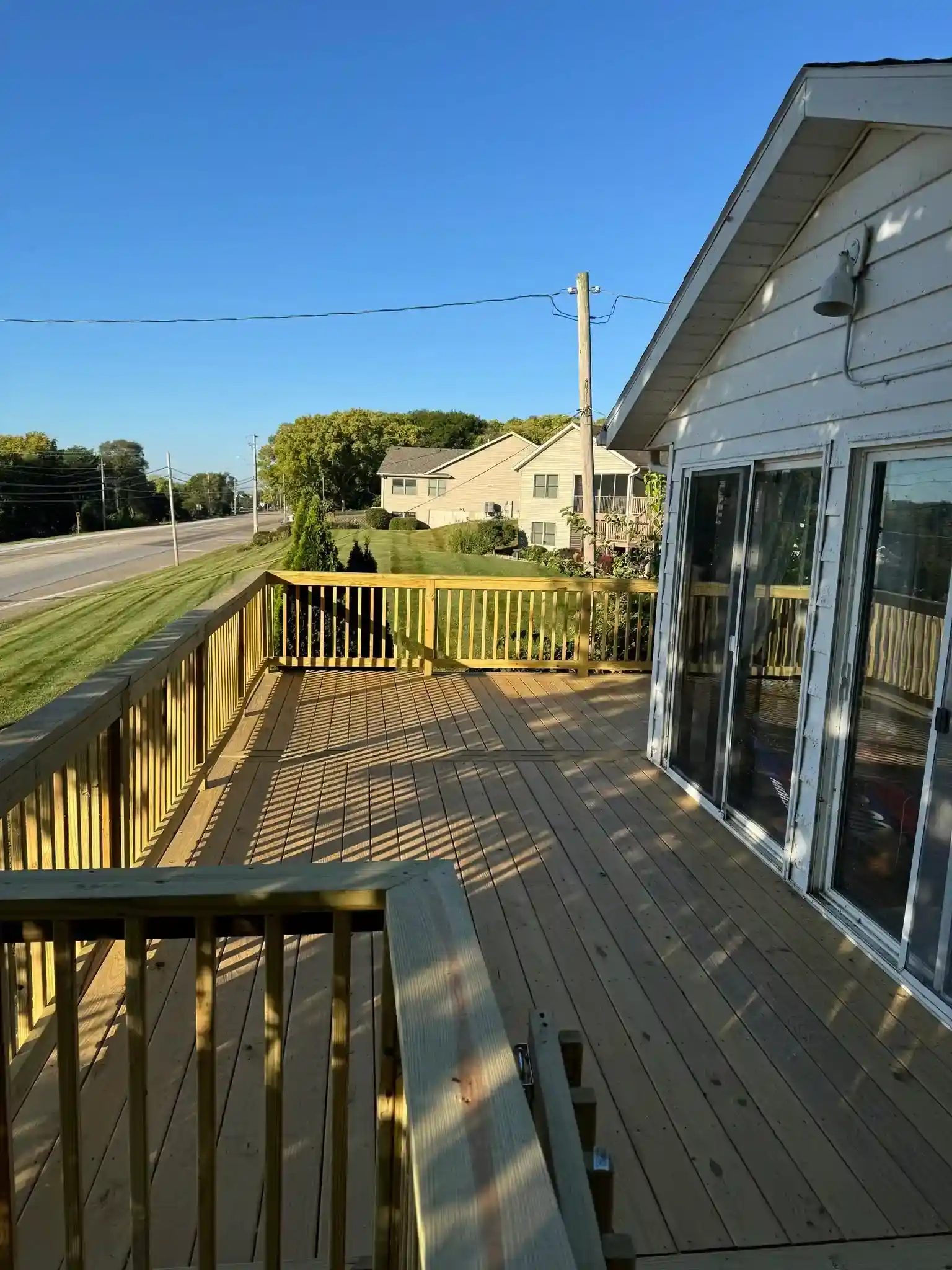 wide wood deck with railing and patio doors in Davenport, Iowa