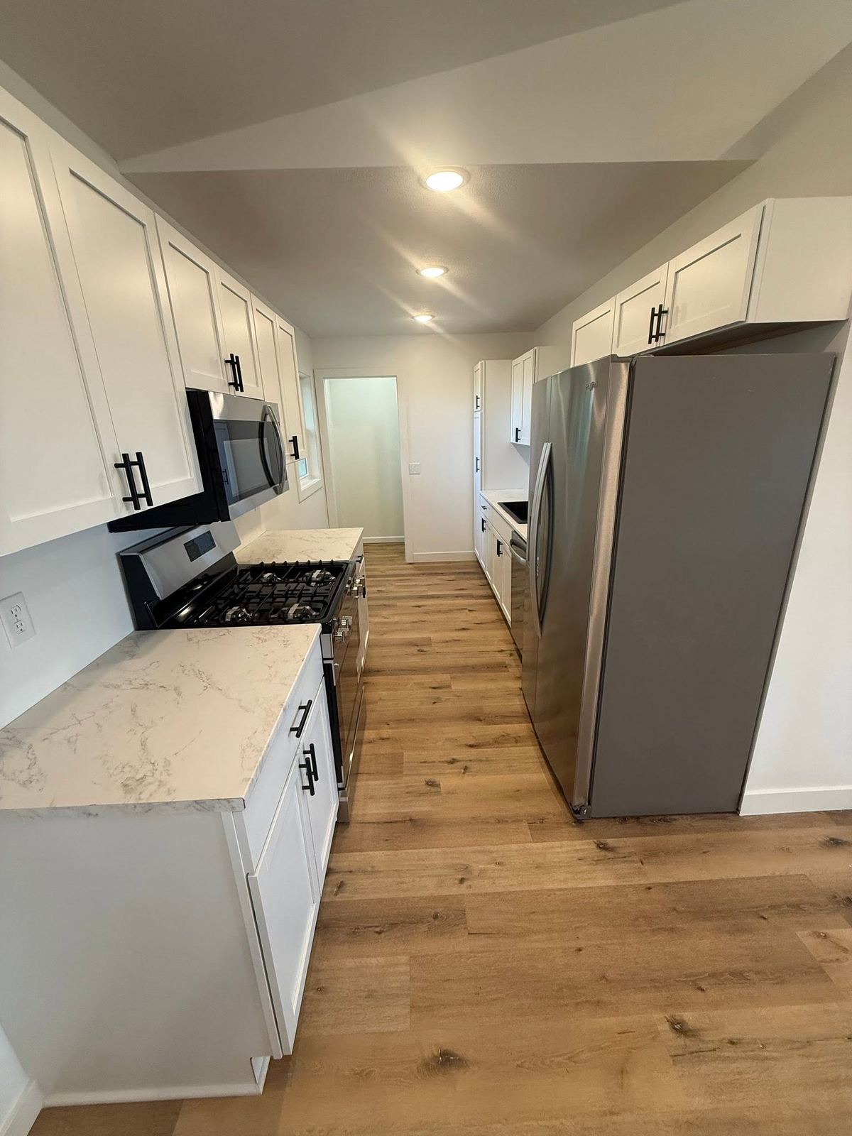 Galley kitchen white cabinets wood floor Davenport IA